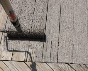 application of natural color armorrenew to wood deck with roller